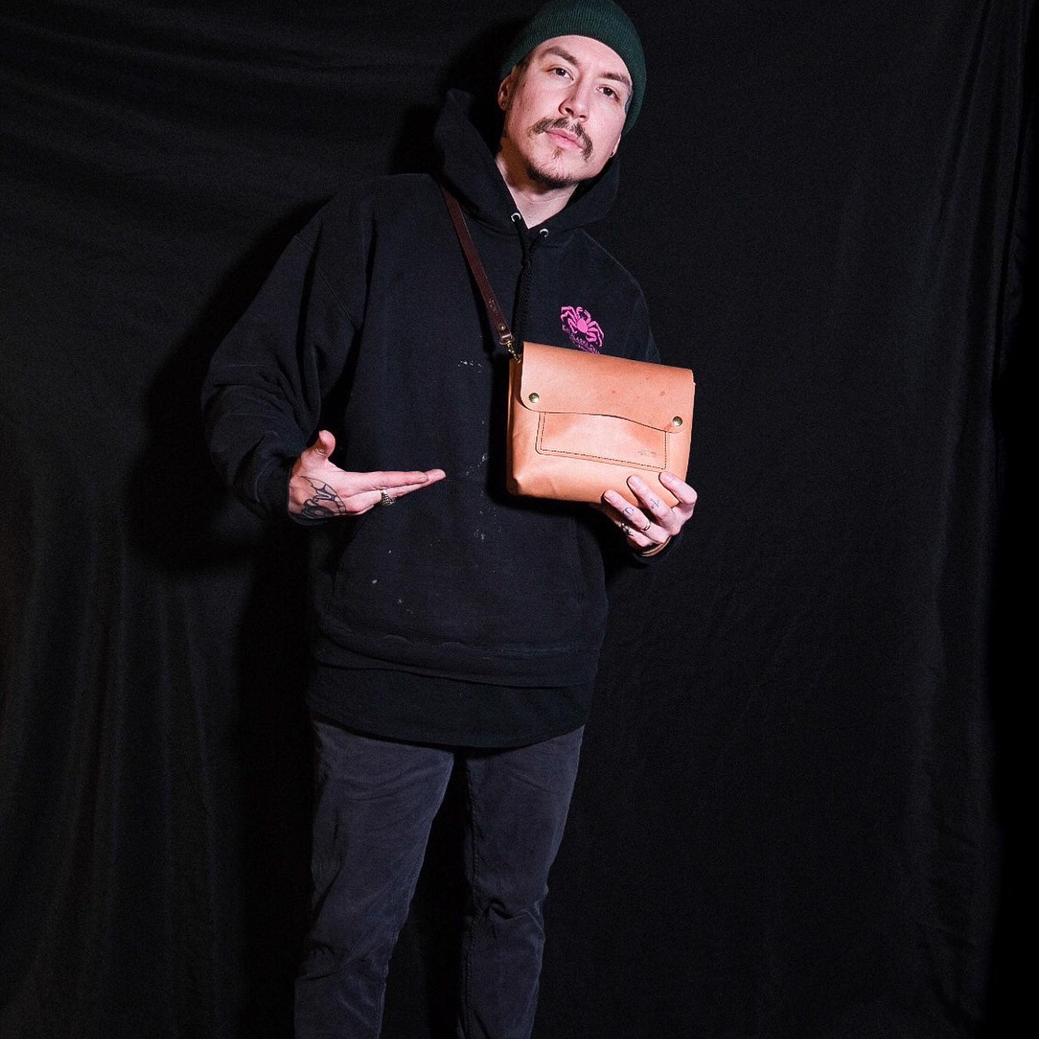 image of Loathed in the USA shop owner Cayden Carle with his handcrafted leather bag