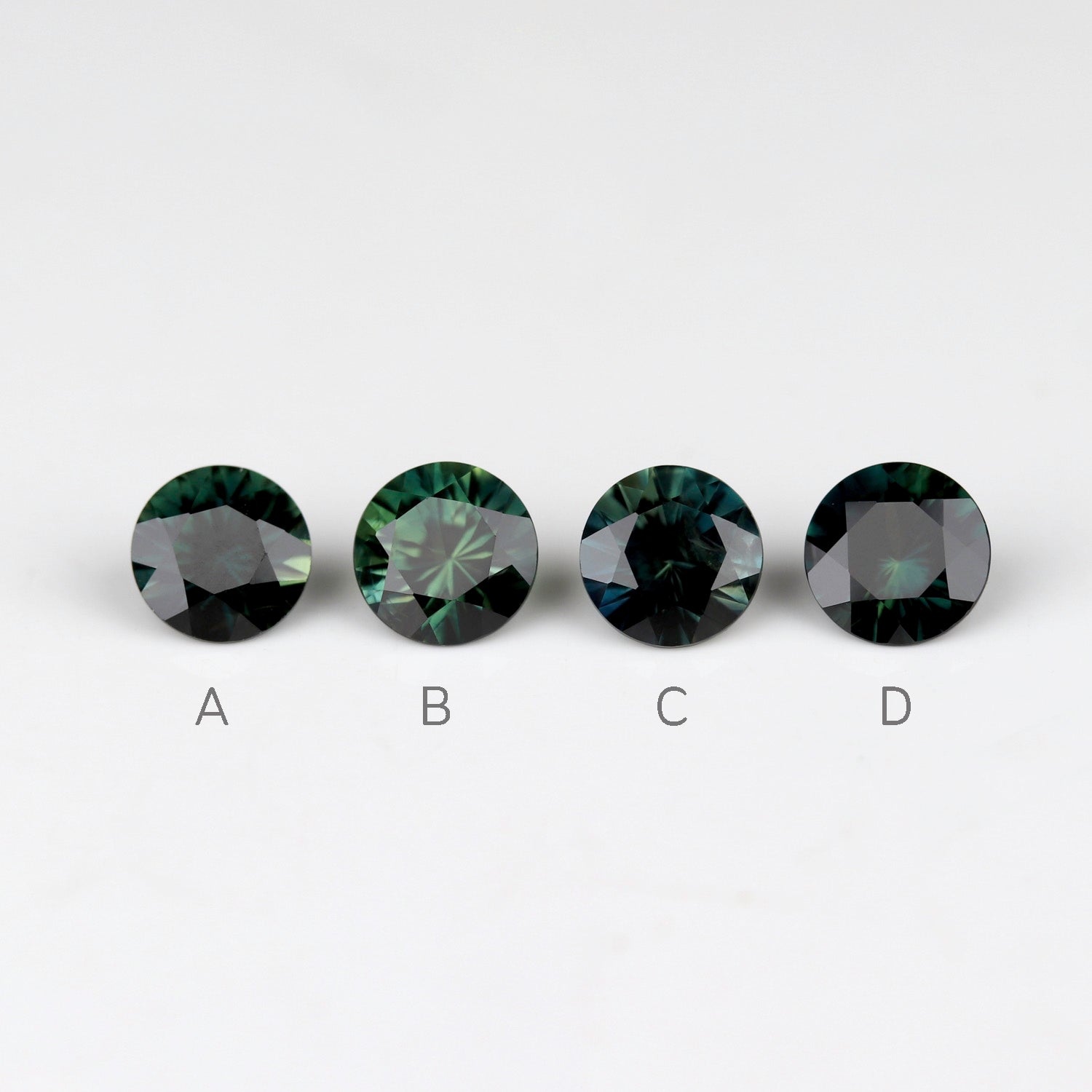 Dark green Australian sapphires in a 4mm diameter size. Stones are labelled from left to right.
