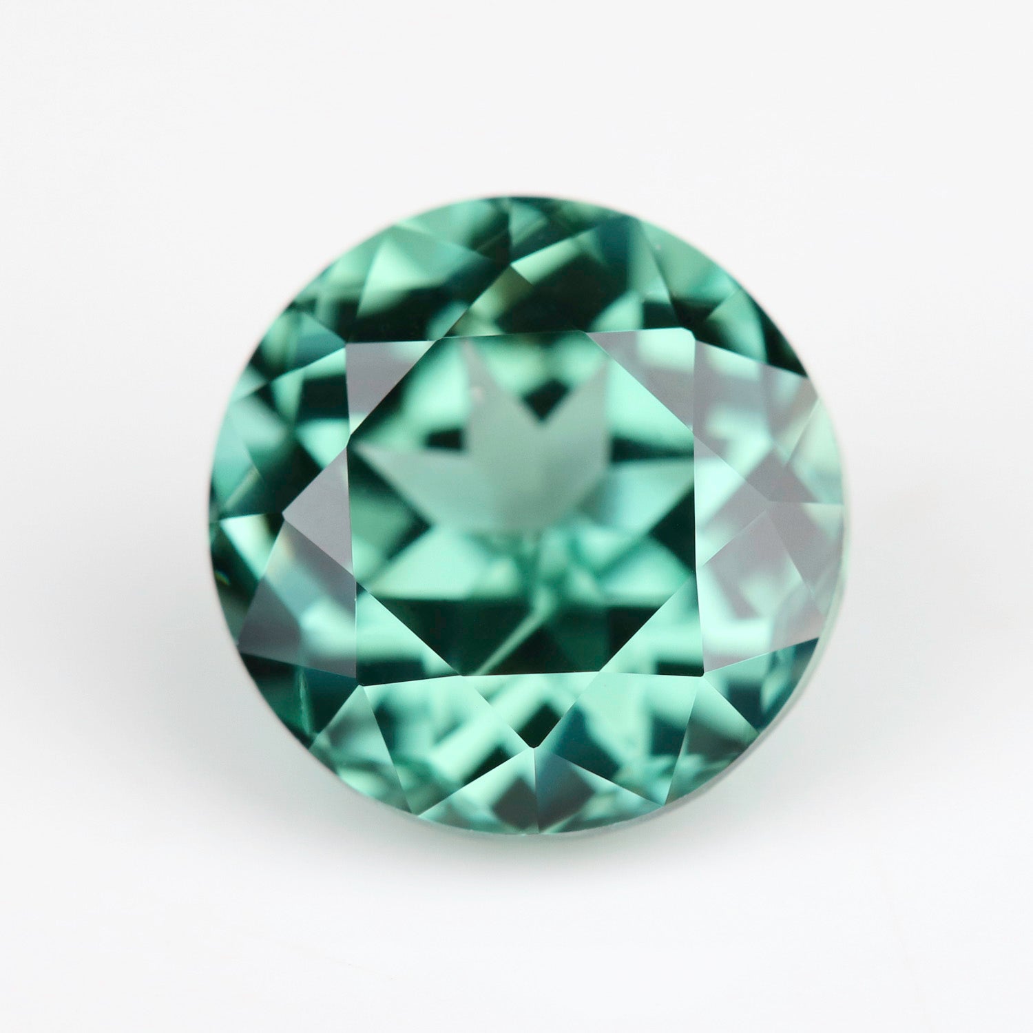 A 7mm round lab-grown green sapphire.
