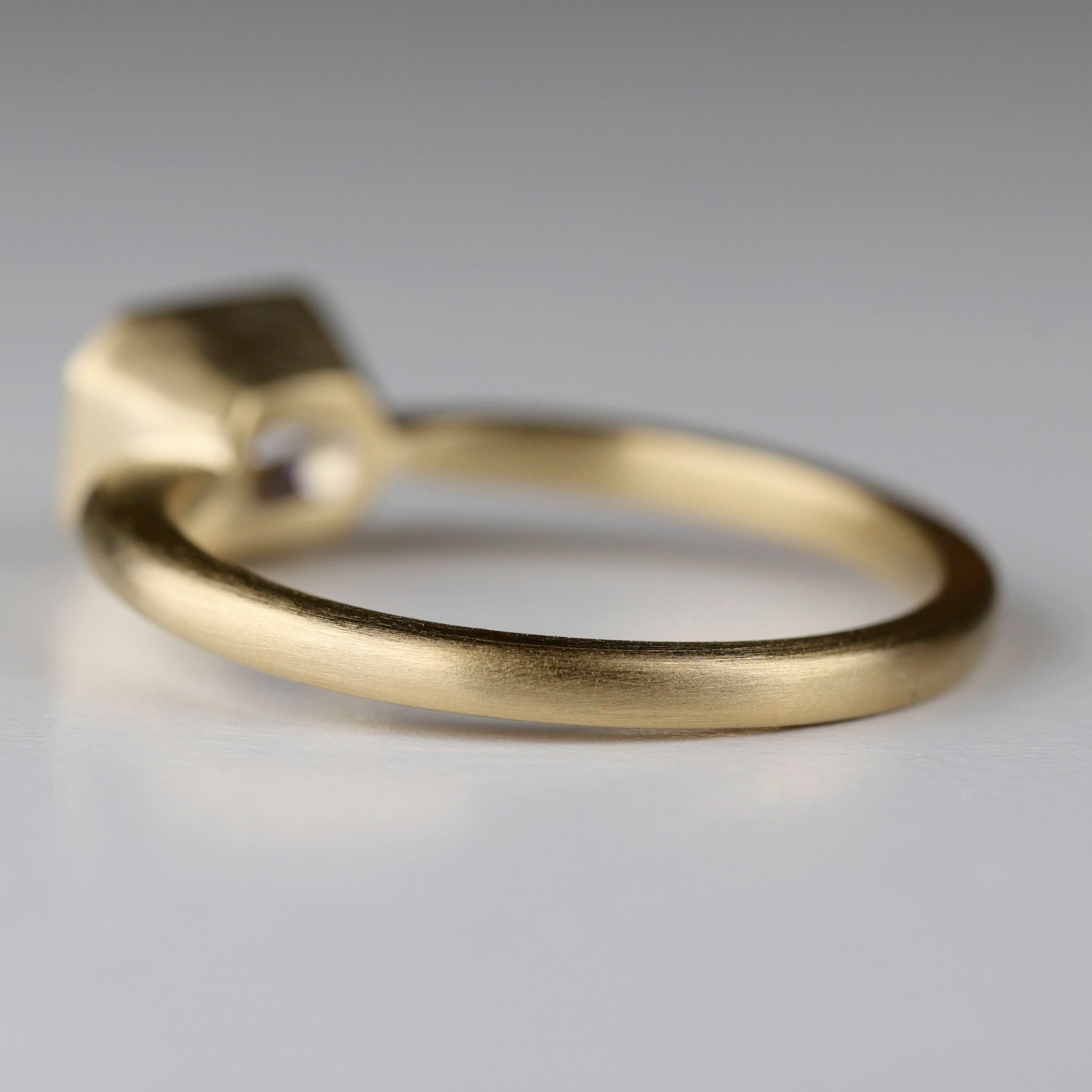 Back angle of a bezel set solitaire. The center setting is set in an East-West orientation.