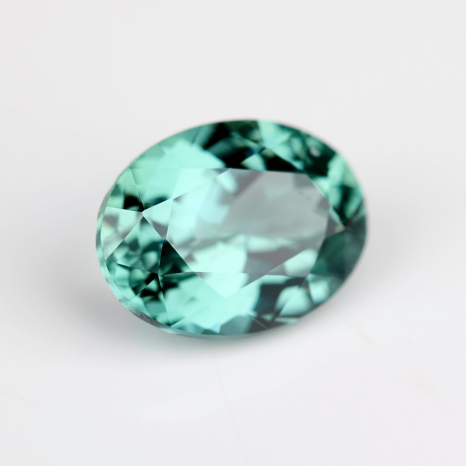 A lab-grown green oval sapphire in a 8x6mm size. The stone is saturated mint green color.