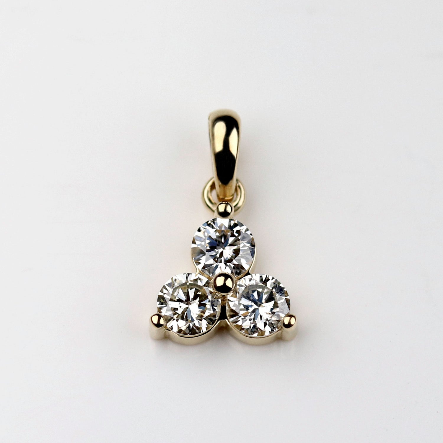 A shiny 14k yellow gold trinity pendant. This pendant has three white diamonds.