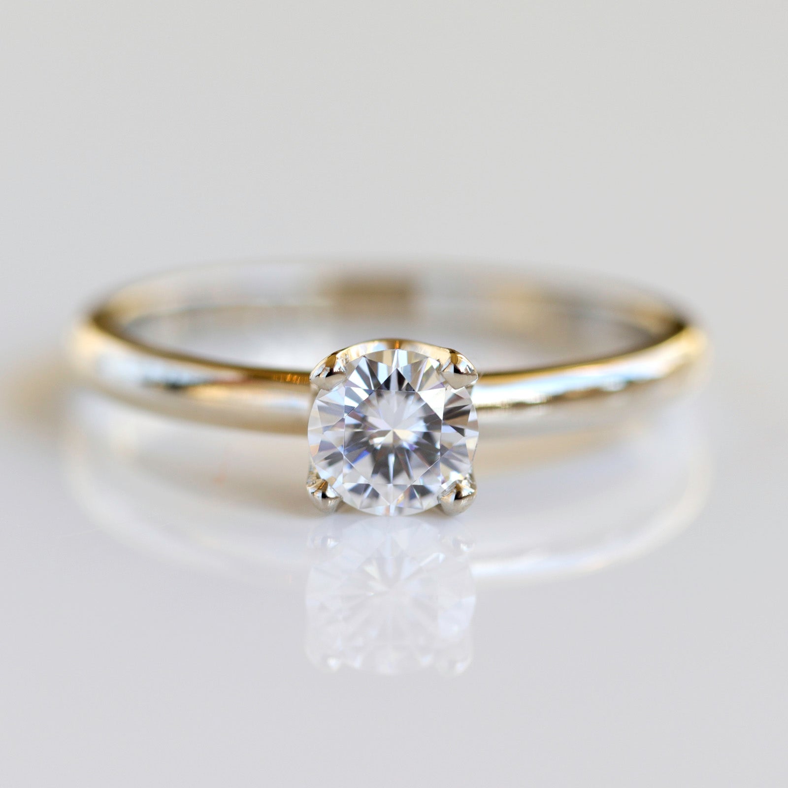 Solitaire engagement ring with a prong-set white diamond. The center stone is around 5mm in diameter. 