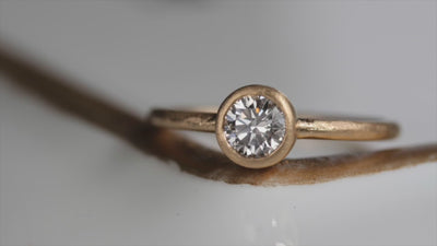 Video of a bezel-set solitaire engagement ring. The video shows different customized versions of the ring style with sapphires and salt & pepper diamonds.